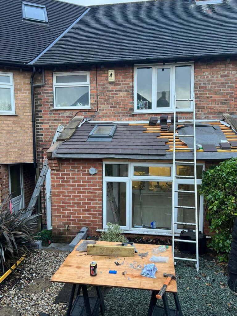 This is a photo of a roof extension that is having new roof tiles installed. This is a photo taken from the roof ridge looking down a tiled pitched roof on to a flat roof. Works carried out by Chatteris Roofing Repairs